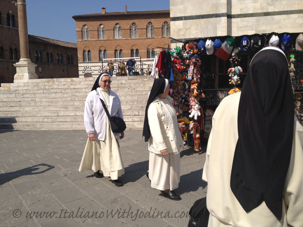 nuns looking at souvenirs piazza duomo siena